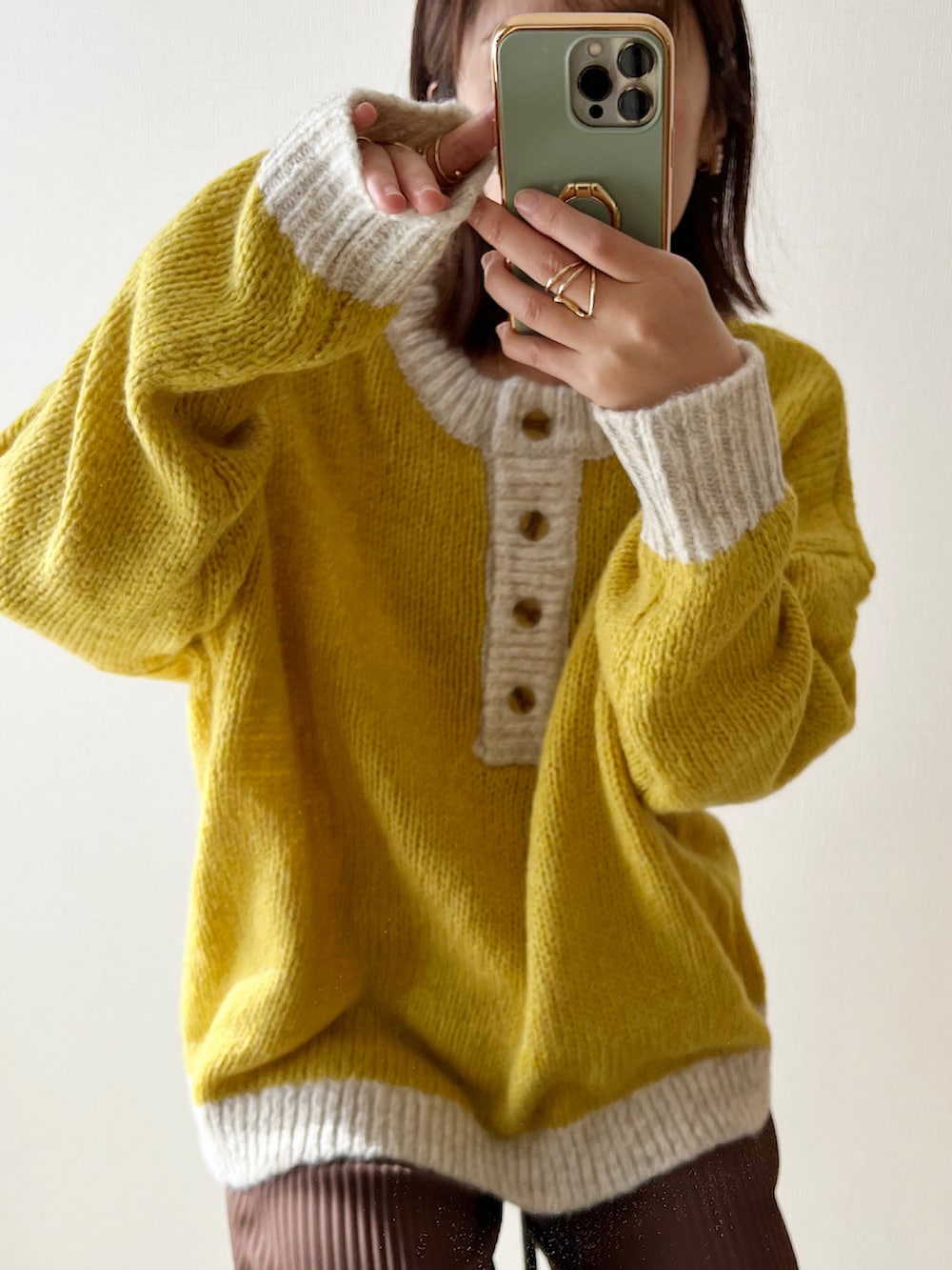 ブラウン系のその他パンツ、ベージュ系のスニーカー、イエロー系のニット/セーターを着用したレディースの秋コーディネートの3枚目の写真