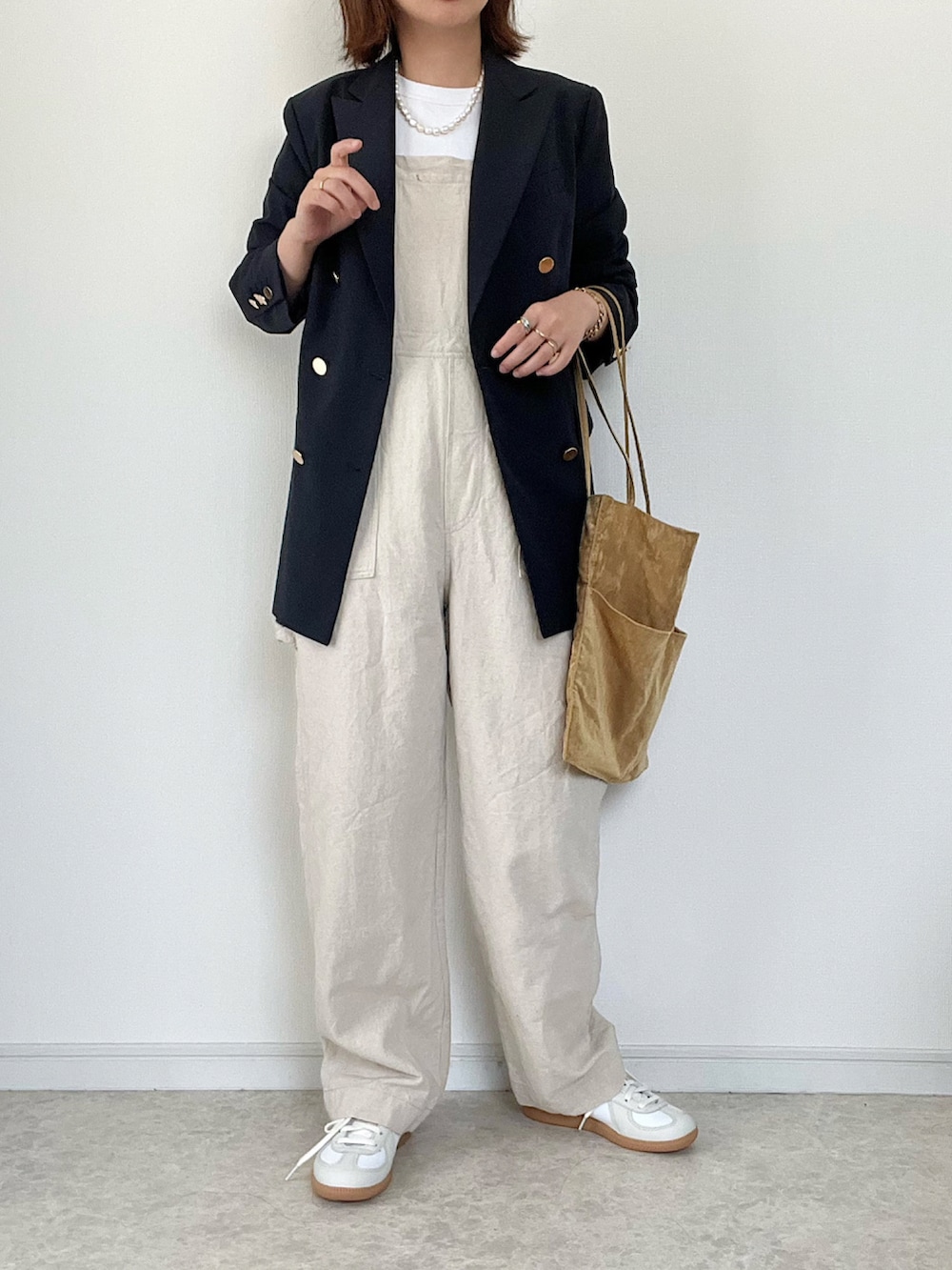 ブルー系のテーラードジャケット、ホワイト系のTシャツ/カットソー、グリーン系のスラックスを着用したレディースの夏コーディネートの2枚目の写真