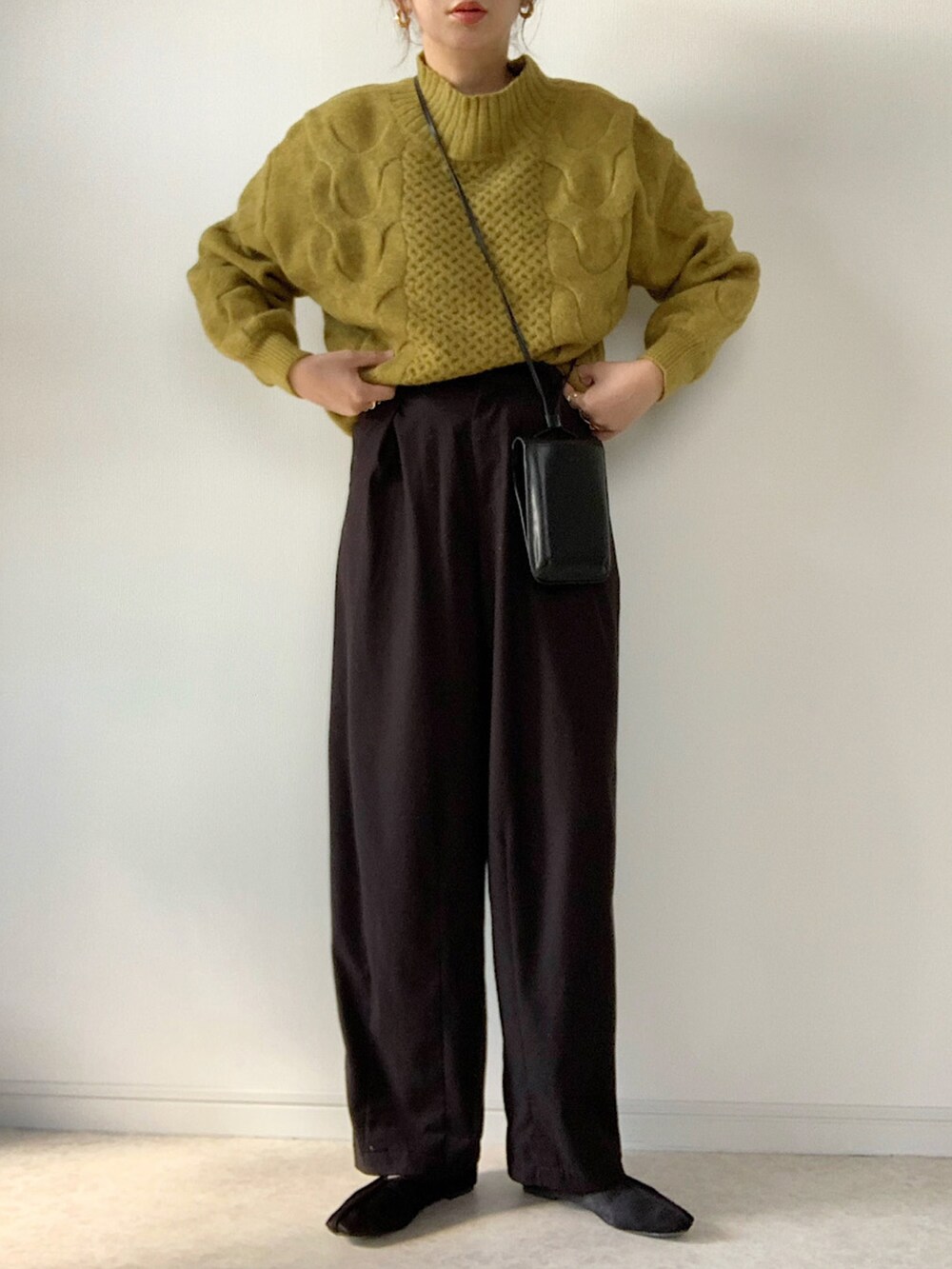 イエロー系のニット/セーター、ブラック系のデニムパンツ、その他のエコバッグ/サブバッグを着用したレディースの冬コーディネートの3枚目の写真