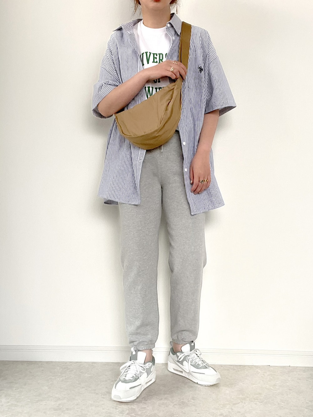 ホワイト系のTシャツ/カットソー、ブラック系のスラックス、ブラック系のショルダーバッグを着用したレディースの夏コーディネートの3枚目の写真