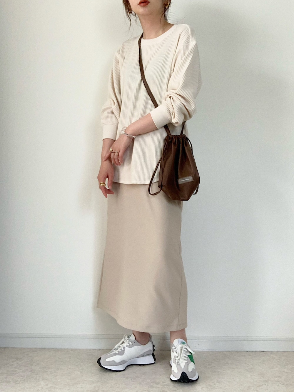 ホワイト系のTシャツ/カットソー、ブルー系のデニムパンツ、ブラック系のショルダーバッグを着用したレディースの春コーディネートの2枚目の写真