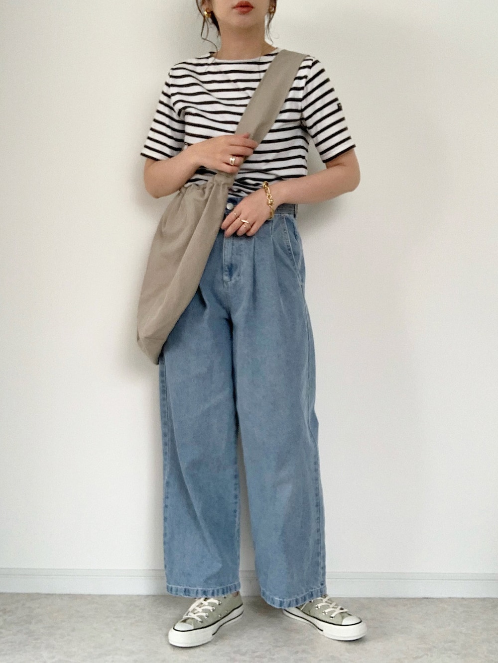 ホワイト系のTシャツ/カットソー、ブルー系のデニムパンツ、ホワイト系のサンダルを着用したレディースの春コーディネートの2枚目の写真