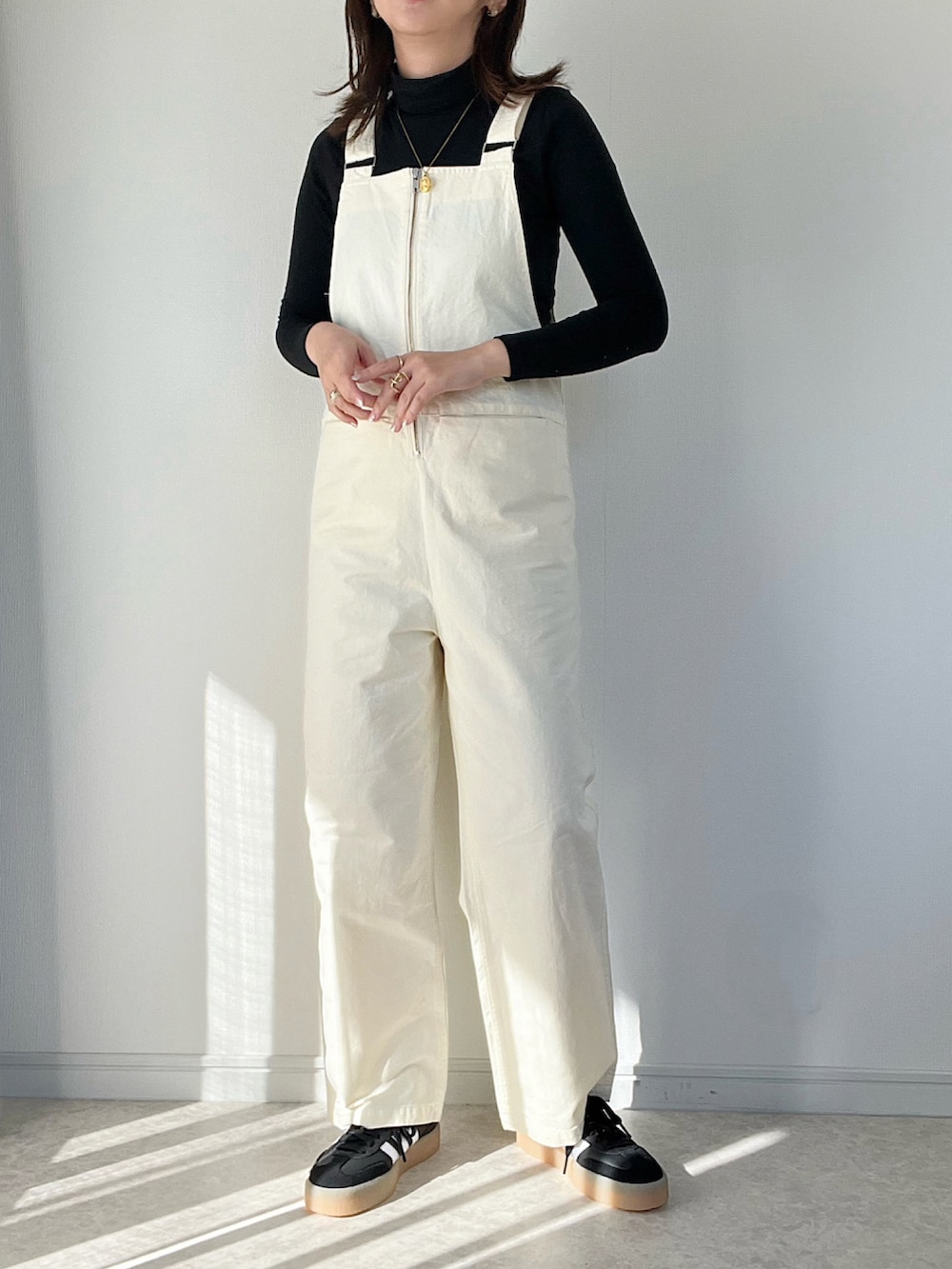 ブラック系のダウンジャケット/コート、ホワイト系のサロペット/オーバーオール、ベージュ系のトートバッグを着用したレディースの冬コーディネートの2枚目の写真