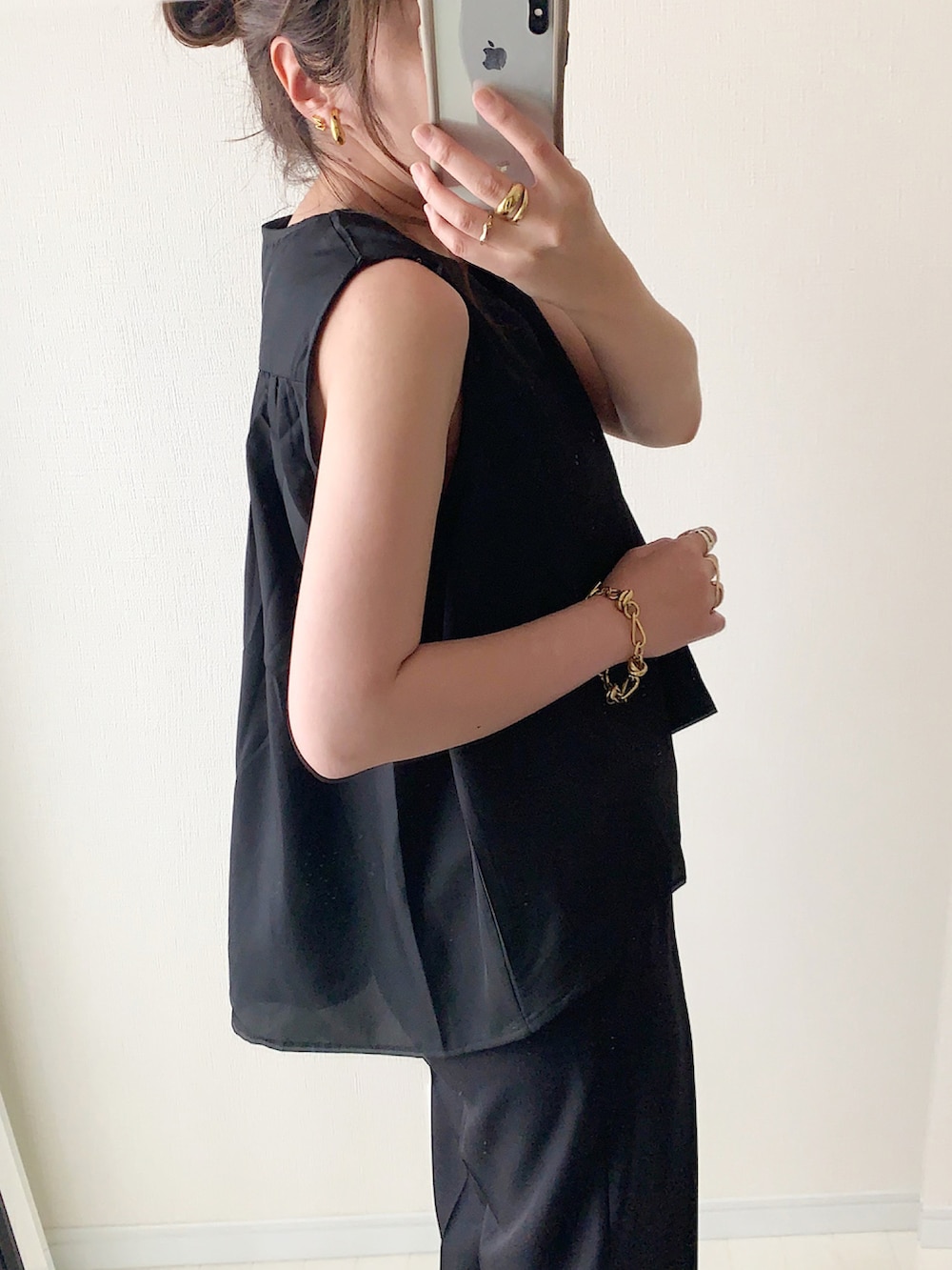 ブラック系のシャツ/ブラウス、ホワイト系のパンツ、ブラック系のサンダルを着用したレディースの夏コーディネートの3枚目の写真