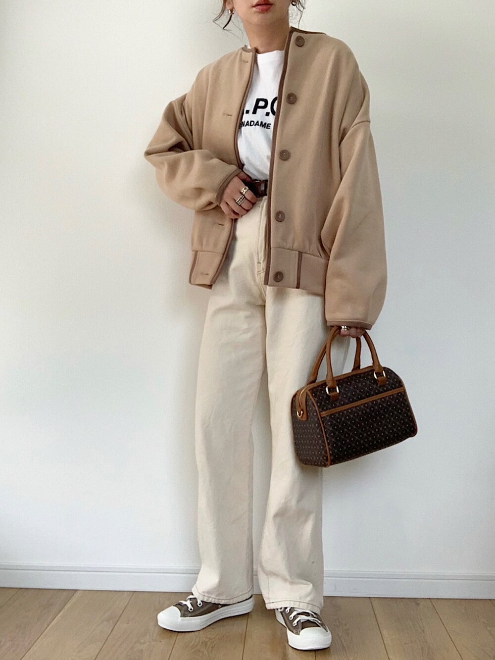 ベージュ系のカーディガン/ボレロ、ブラック系のTシャツ/カットソー、ホワイト系のデニムパンツを着用したレディースの秋コーディネートの5枚目の写真