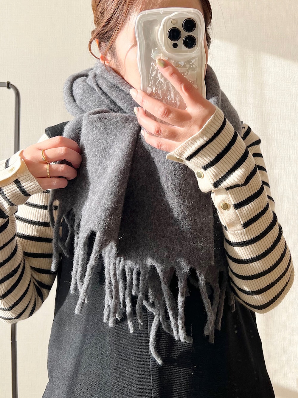 ホワイト系のニット/セーター、グレー系のパンツ、ベージュ系のトートバッグを着用したレディースの冬コーディネートの2枚目の写真