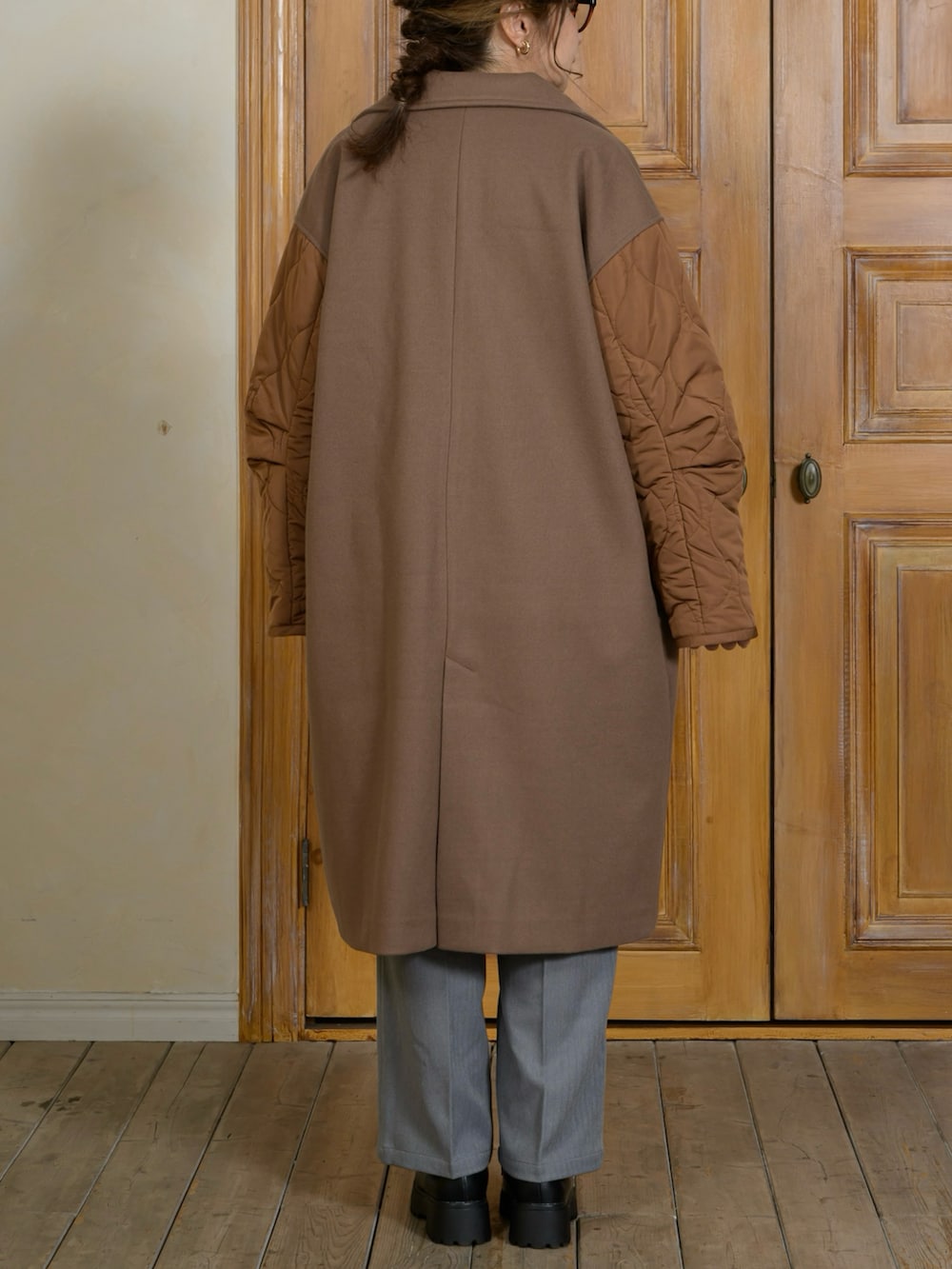 ブラック系のジャケット/アウター、オレンジ系のニット/セーター、グレー系のパンツを着用したレディースの秋コーディネートの2枚目の写真