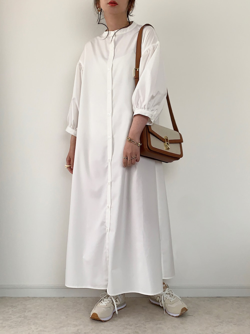 ホワイト系のシャツワンピース、ホワイト系のTシャツ/カットソー、ベージュ系のかごバッグを着用したレディースの春コーディネートの3枚目の写真