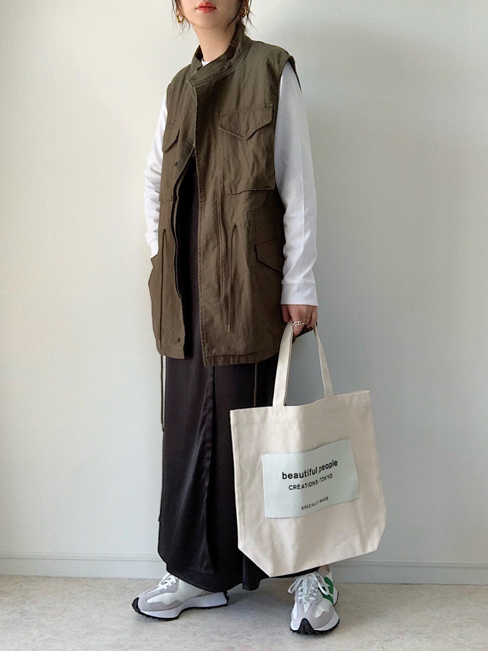 ホワイト系のTシャツ/カットソー、ブラック系のワンピース、ベージュ系のショルダーバッグを着用したレディースの春コーディネートの3枚目の写真