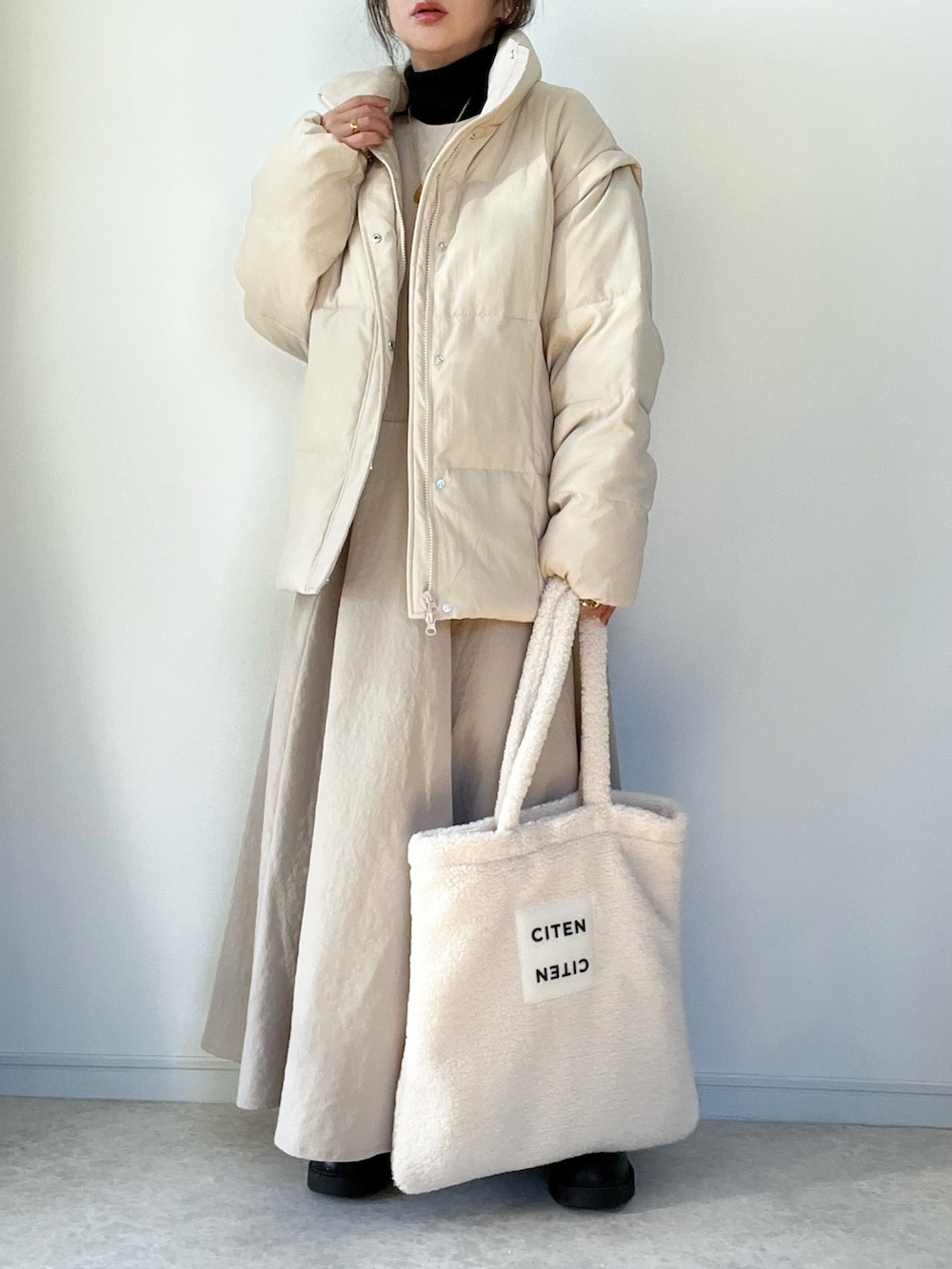 ホワイト系のダウンジャケット/コート、ホワイト系のニット/セーター、グリーン系のカーゴパンツを着用したレディースの秋コーディネートの2枚目の写真