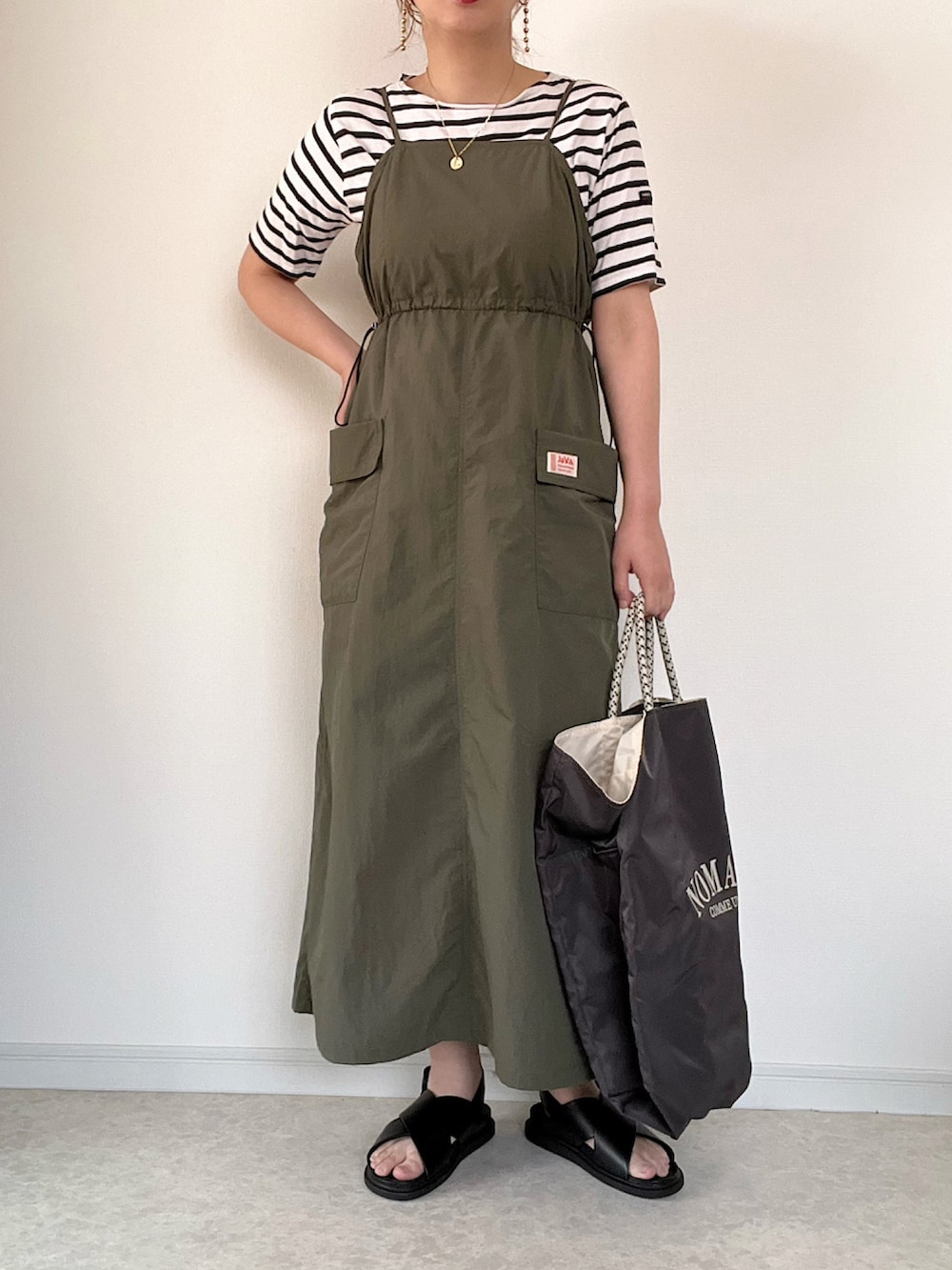 ホワイト系のカーディガン/ボレロ、グリーン系のワンピース、グレー系のスニーカーを着用したレディースの春コーディネートの3枚目の写真