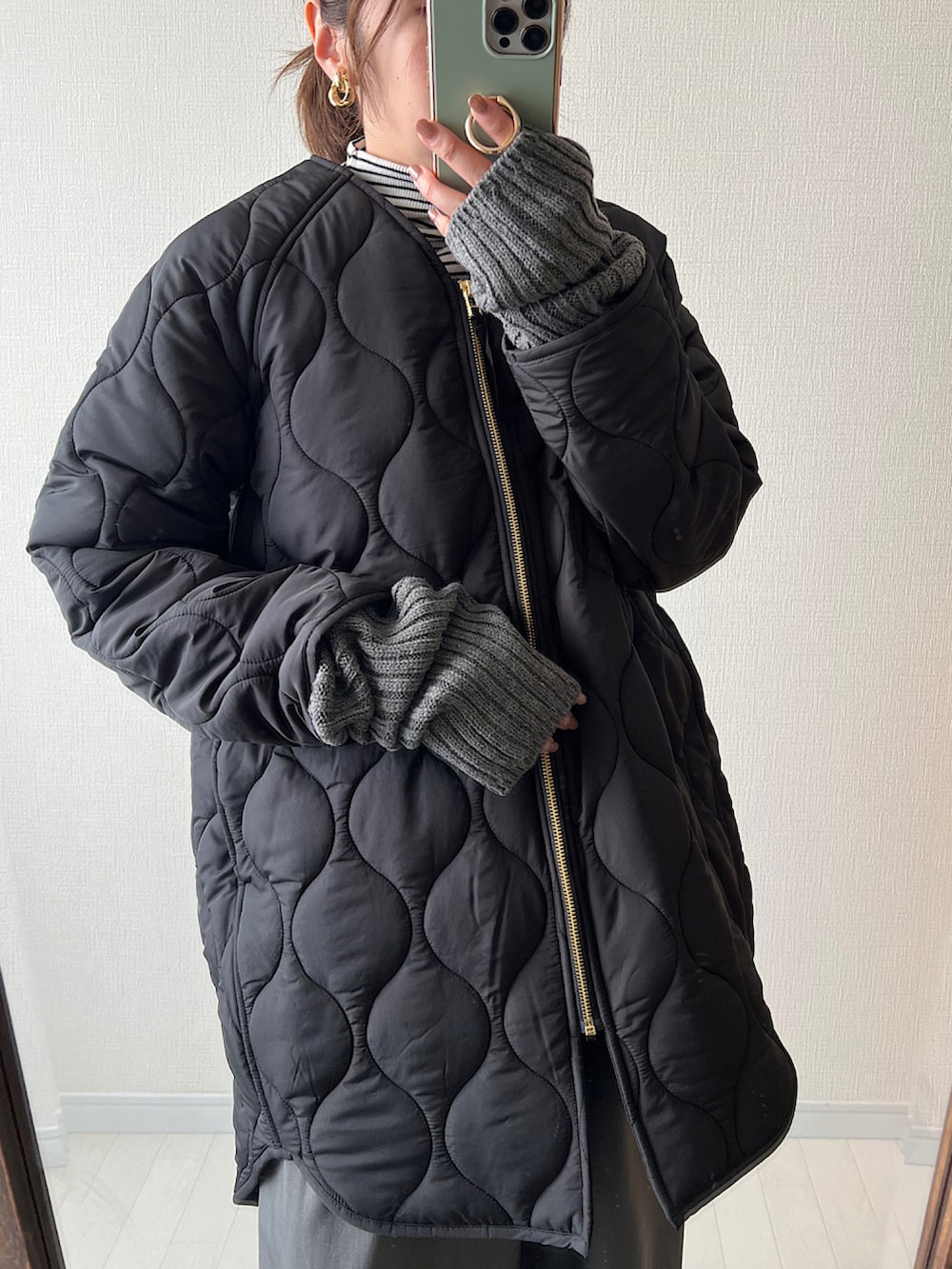 ブラック系のその他アウター、ブラック系のスラックス、ベージュ系のトートバッグを着用したレディースの冬コーディネートの2枚目の写真