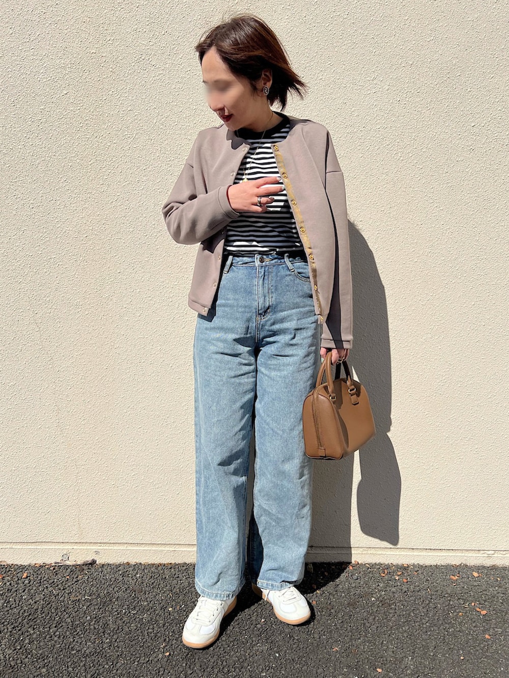 ブルー系のデニムパンツ、ホワイト系のスニーカー、ブラウン系のトップスを着用したレディースの春コーディネートの3枚目の写真