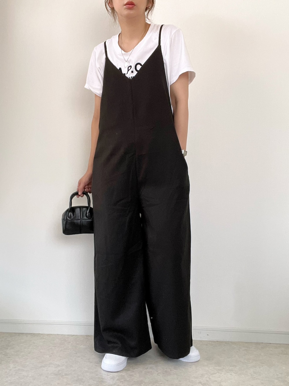 ベージュ系のベスト、ブラック系のタンクトップ、ブラック系のサロペット/オーバーオールを着用したレディースの夏コーディネートの3枚目の写真