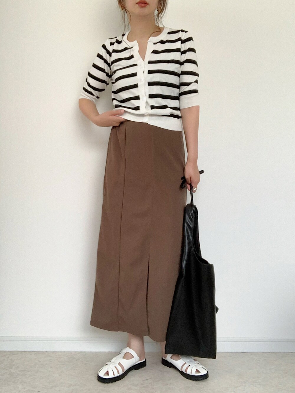 ブラック系のTシャツ/カットソー、ブラウン系のスカート、ブラック系のサンダルを着用したレディースの夏コーディネートの3枚目の写真