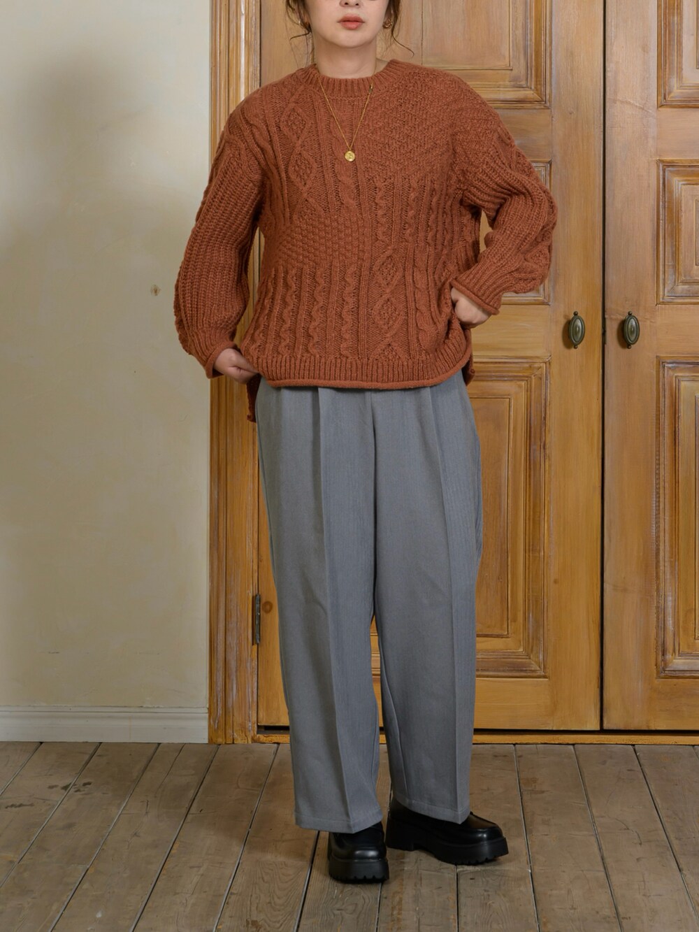 ブラック系のジャケット/アウター、オレンジ系のニット/セーター、グレー系のパンツを着用したレディースの秋コーディネートの3枚目の写真