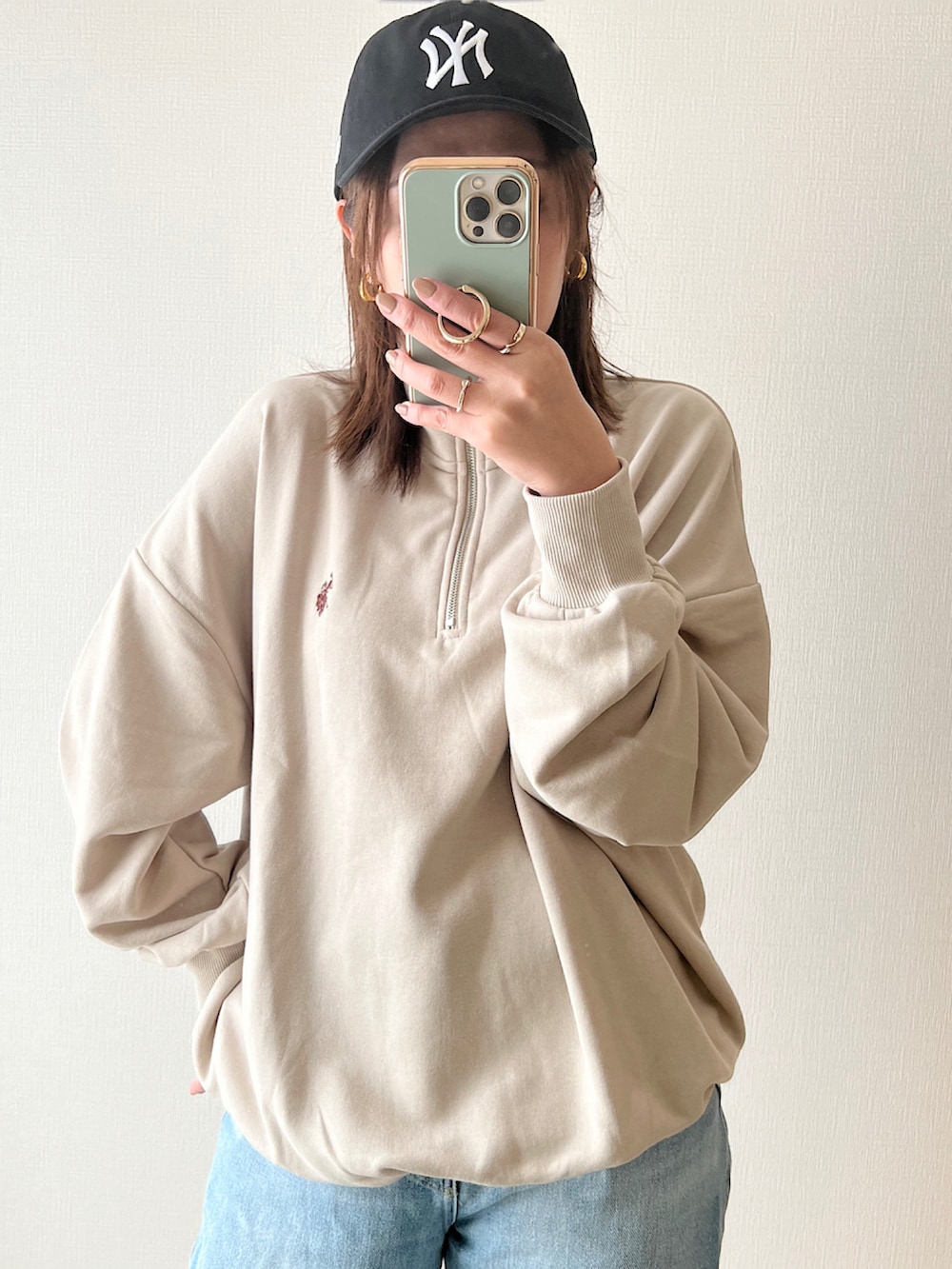 ベージュ系のスウェット、ブルー系のデニムパンツ、ホワイト系のスニーカーを着用したレディースの秋コーディネートの2枚目の写真