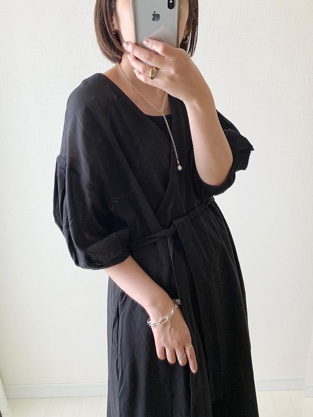 ホワイト系のサンダル、ベージュ系のかごバッグ、ブラック系のワンピースを着用したレディースの夏コーディネートの3枚目の写真