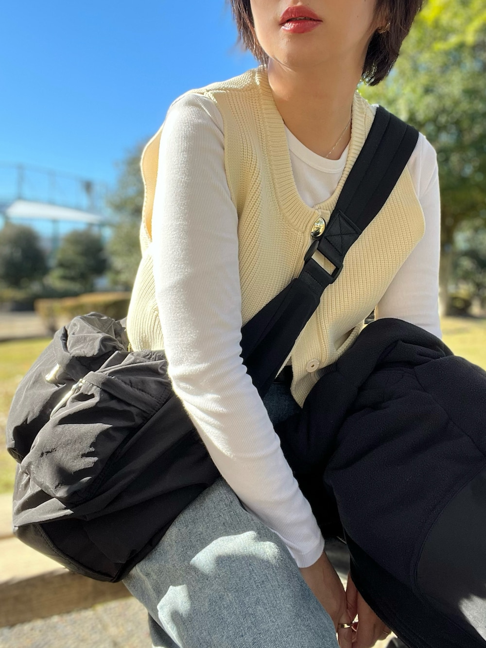 ホワイト系のニット/セーター、ブルー系のデニムパンツ、その他のスニーカーを着用したレディースの冬コーディネートの2枚目の写真