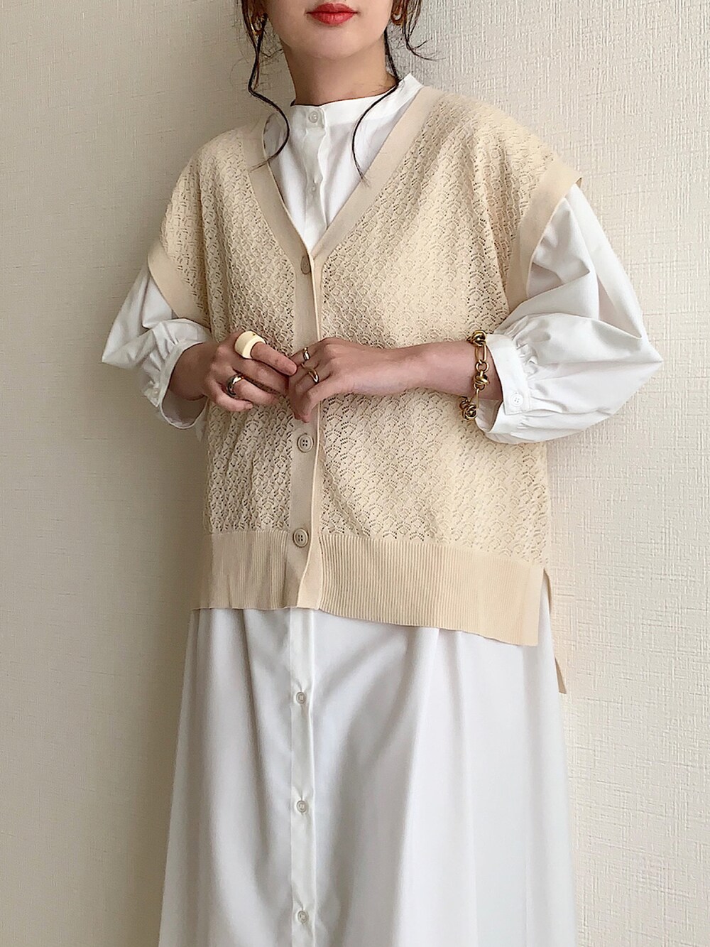 ベージュ系のベスト、ホワイト系のシャツワンピース、イエロー系のショルダーバッグを着用したレディースの夏コーディネートの2枚目の写真