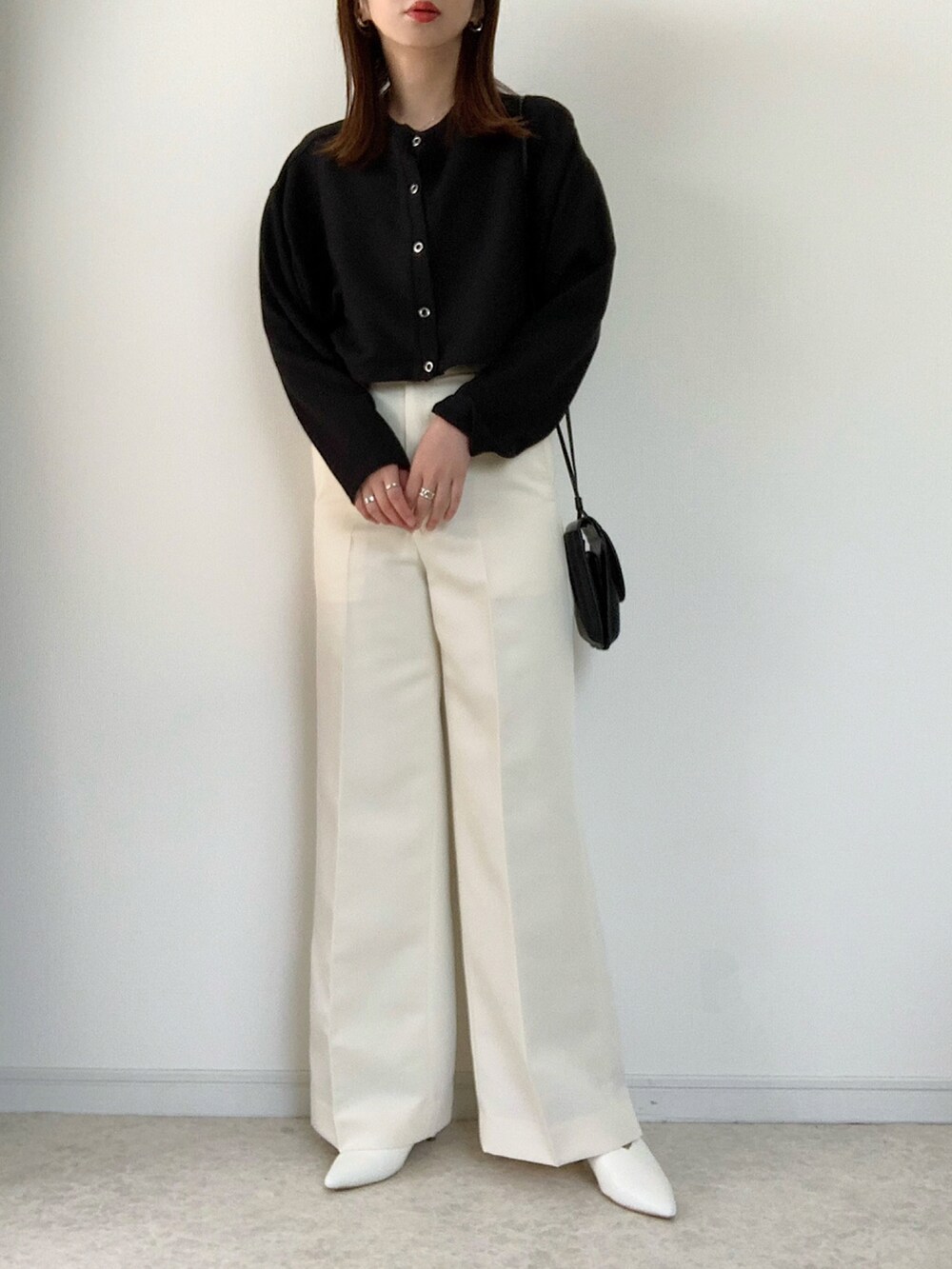 ブラック系のカーディガン/ボレロ、ブラック系のキャミソール、ブラウン系のスラックスを着用したレディースの春コーディネートの2枚目の写真