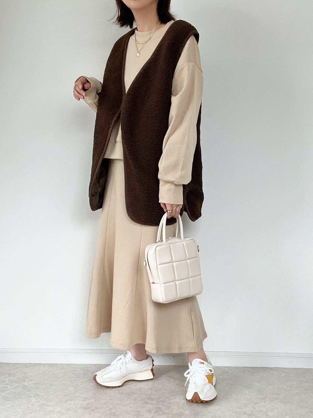 ブラウン系のベスト、ベージュ系のスカート、ベージュ系のシャツ/ブラウスを着用したレディースの秋コーディネートの2枚目の写真