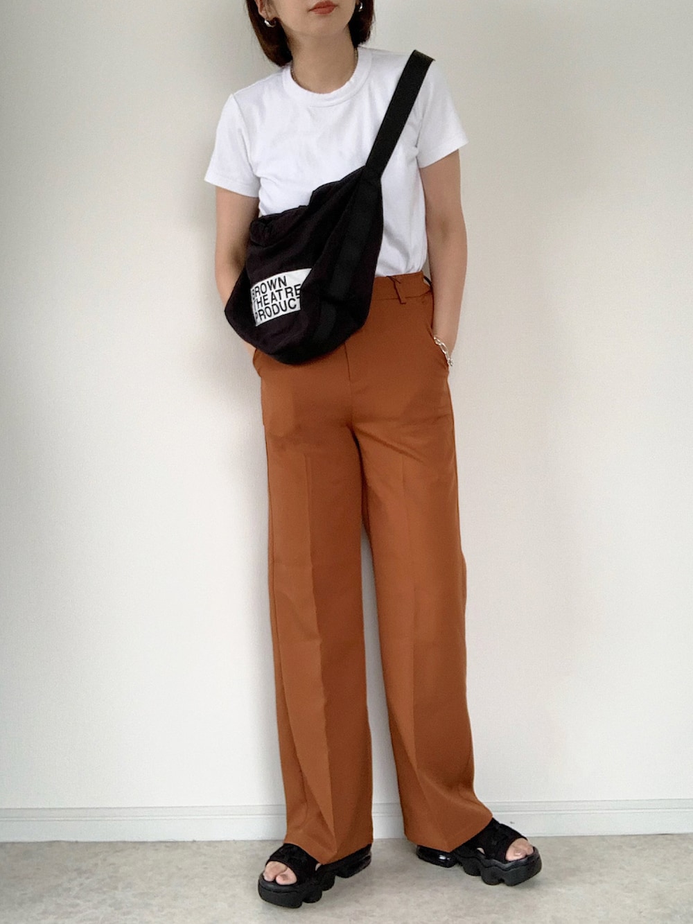 ホワイト系のTシャツ/カットソー、ブラウン系のスラックス、ホワイト系のショルダーバッグを着用したレディースの夏コーディネートの4枚目の写真