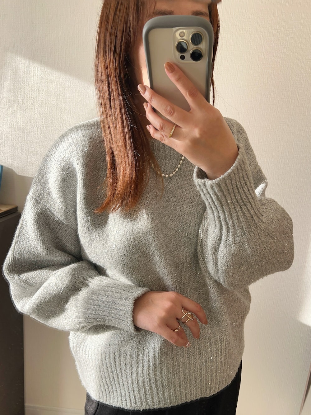 グレー系のニット/セーター、ブラック系のパンツ、ブラック系のトートバッグを着用したレディースの秋コーディネートの2枚目の写真