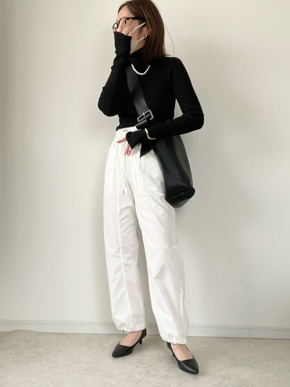 ブラック系のニット/セーター、ブルー系のデニムパンツ、ブラウン系のパンプスを着用したレディースの秋コーディネートの3枚目の写真