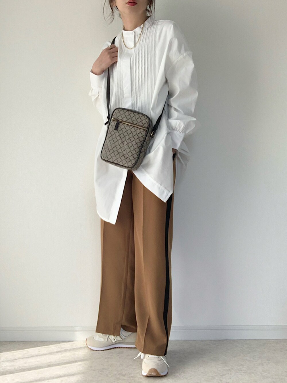 ホワイト系のシャツ/ブラウス、ブラック系のパンツ、ブラック系のショルダーバッグを着用したレディースの冬コーディネートの3枚目の写真