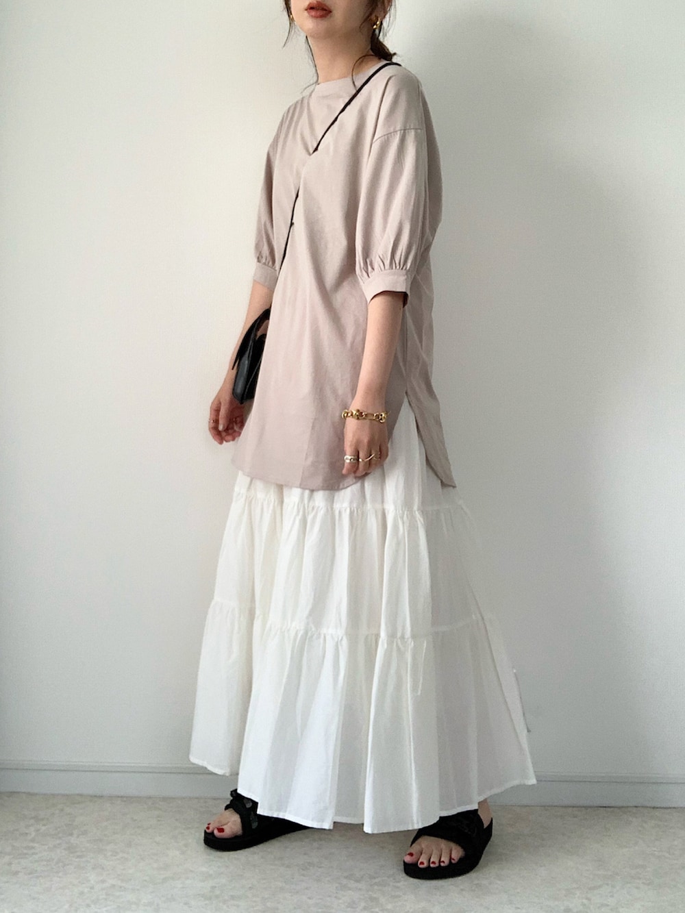 ブラック系のTシャツ/カットソー、ホワイト系のスカート、ブラック系のサンダルを着用したレディースの春コーディネートの4枚目の写真