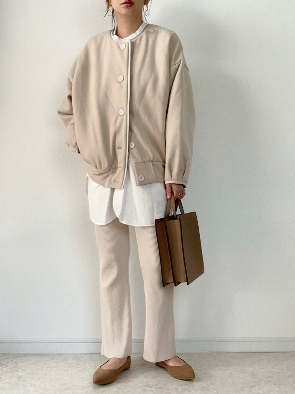 ベージュ系のカーディガン/ボレロ、ブルー系のデニムパンツ、ブラウン系のバッグを着用したレディースの秋コーディネートの2枚目の写真