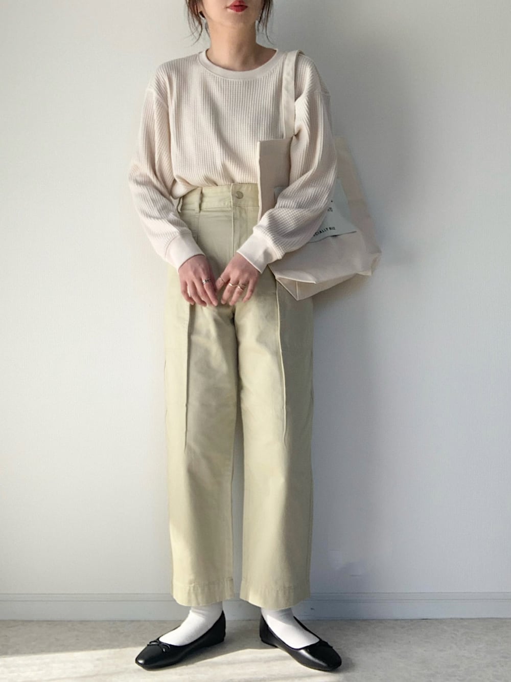 ホワイト系のTシャツ/カットソー、グレー系のニット/セーター、ブラック系のショルダーバッグを着用したレディースの冬コーディネートの4枚目の写真