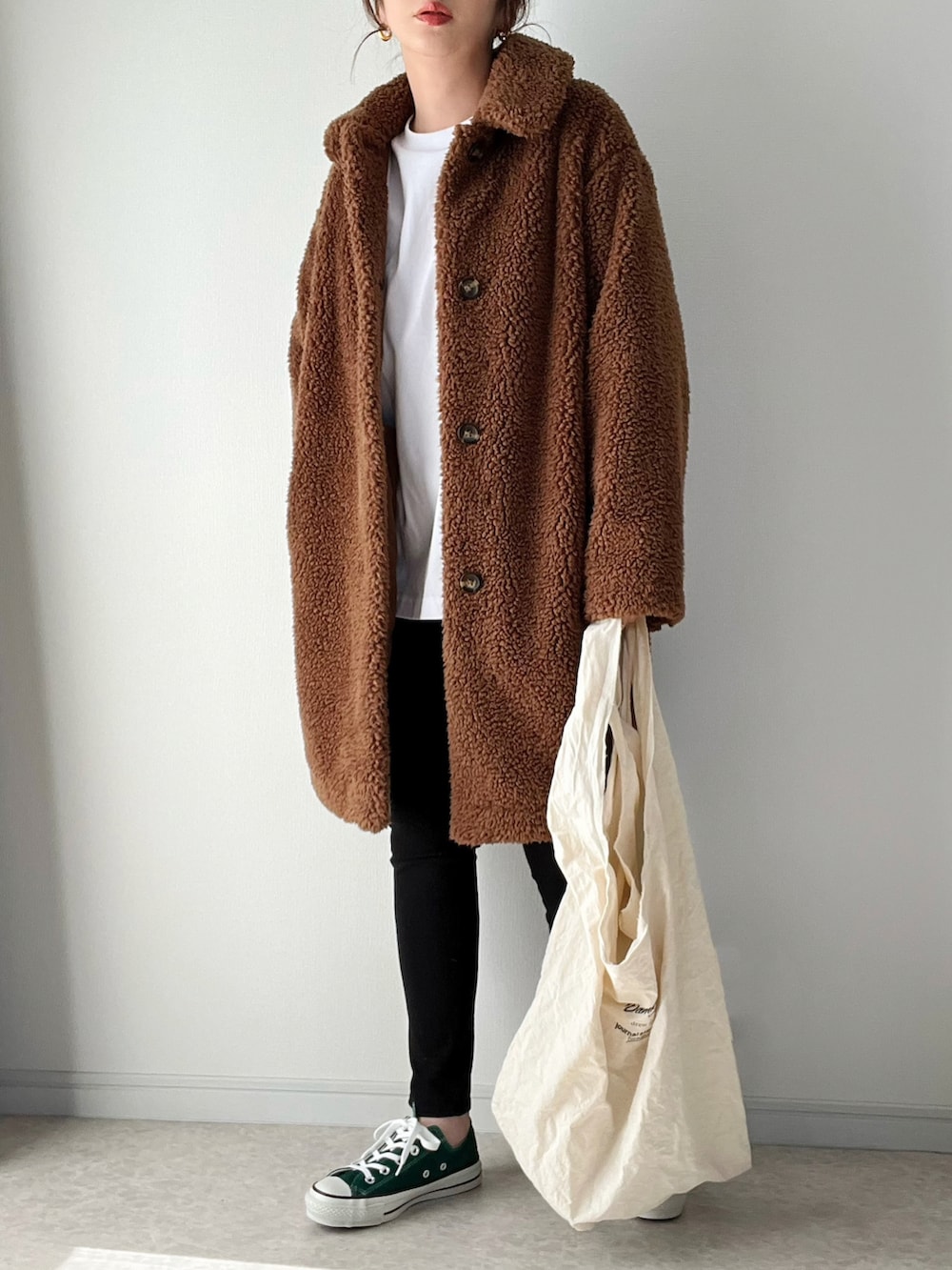 ホワイト系のブルゾン、ホワイト系のトートバッグ、グリーン系のスニーカーを着用したレディースの冬コーディネートの2枚目の写真