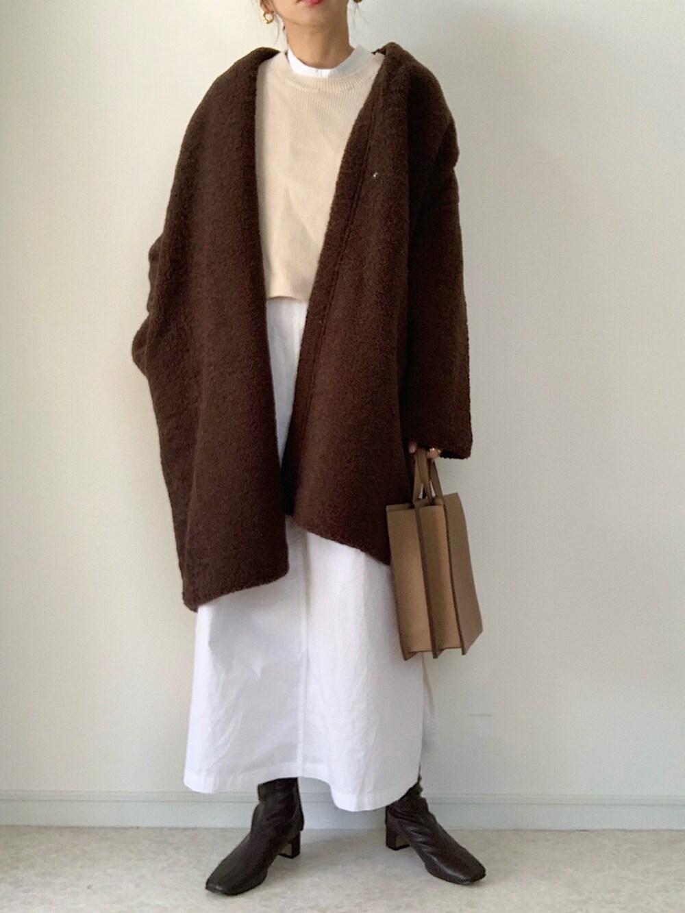 ブラウン系のノーカラーコート、ブラック系のスウェット、グレー系のその他パンツを着用したレディースの秋コーディネートの2枚目の写真