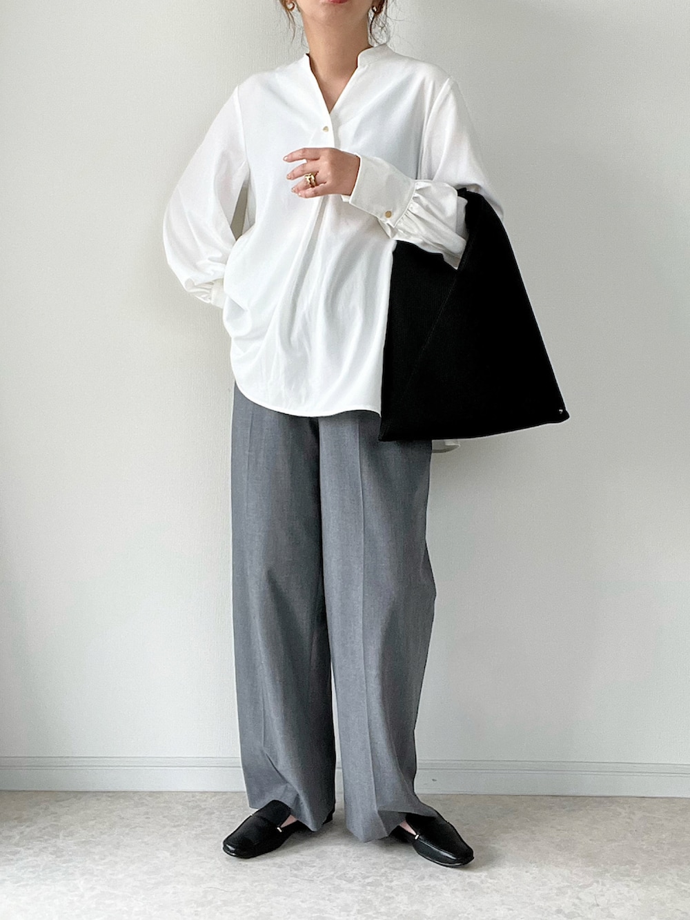 ホワイト系のシャツ/ブラウス、グレー系のパンツ、ブラック系のトートバッグを着用したレディースの秋コーディネートの2枚目の写真