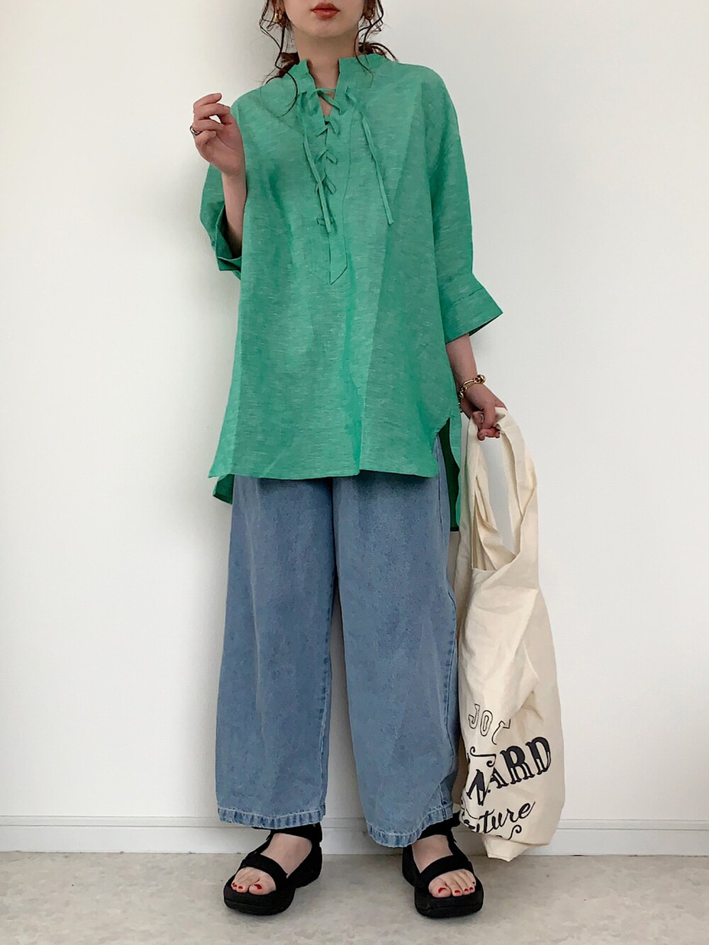 ホワイト系のTシャツ/カットソー、ブルー系のデニムパンツ、ホワイト系のサンダルを着用したレディースの春コーディネートの3枚目の写真