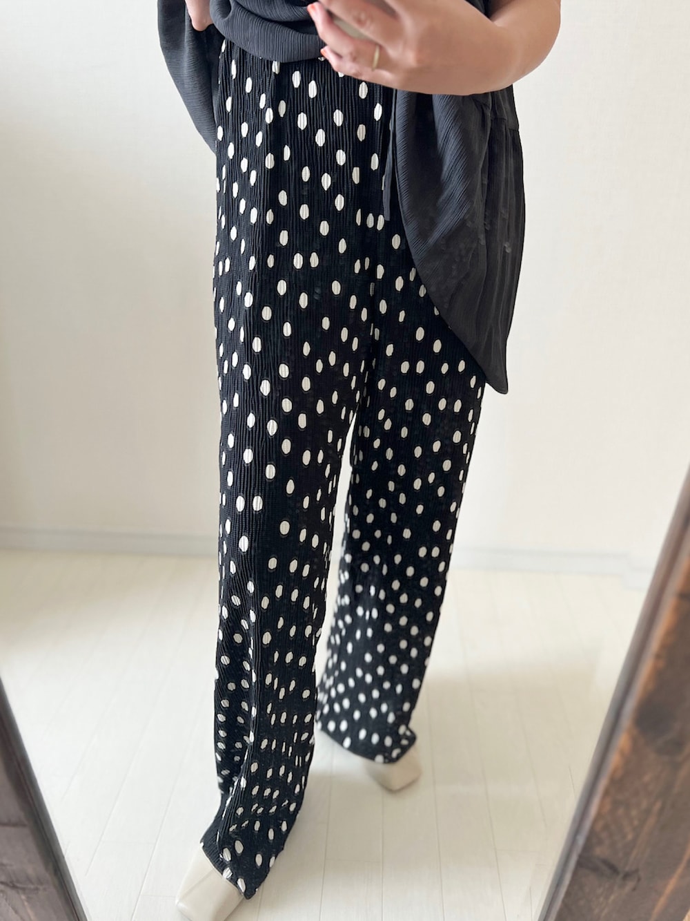 ホワイト系のチュニック、ブラック系のその他パンツ、ブラック系のトートバッグを着用したレディースの夏コーディネートの2枚目の写真