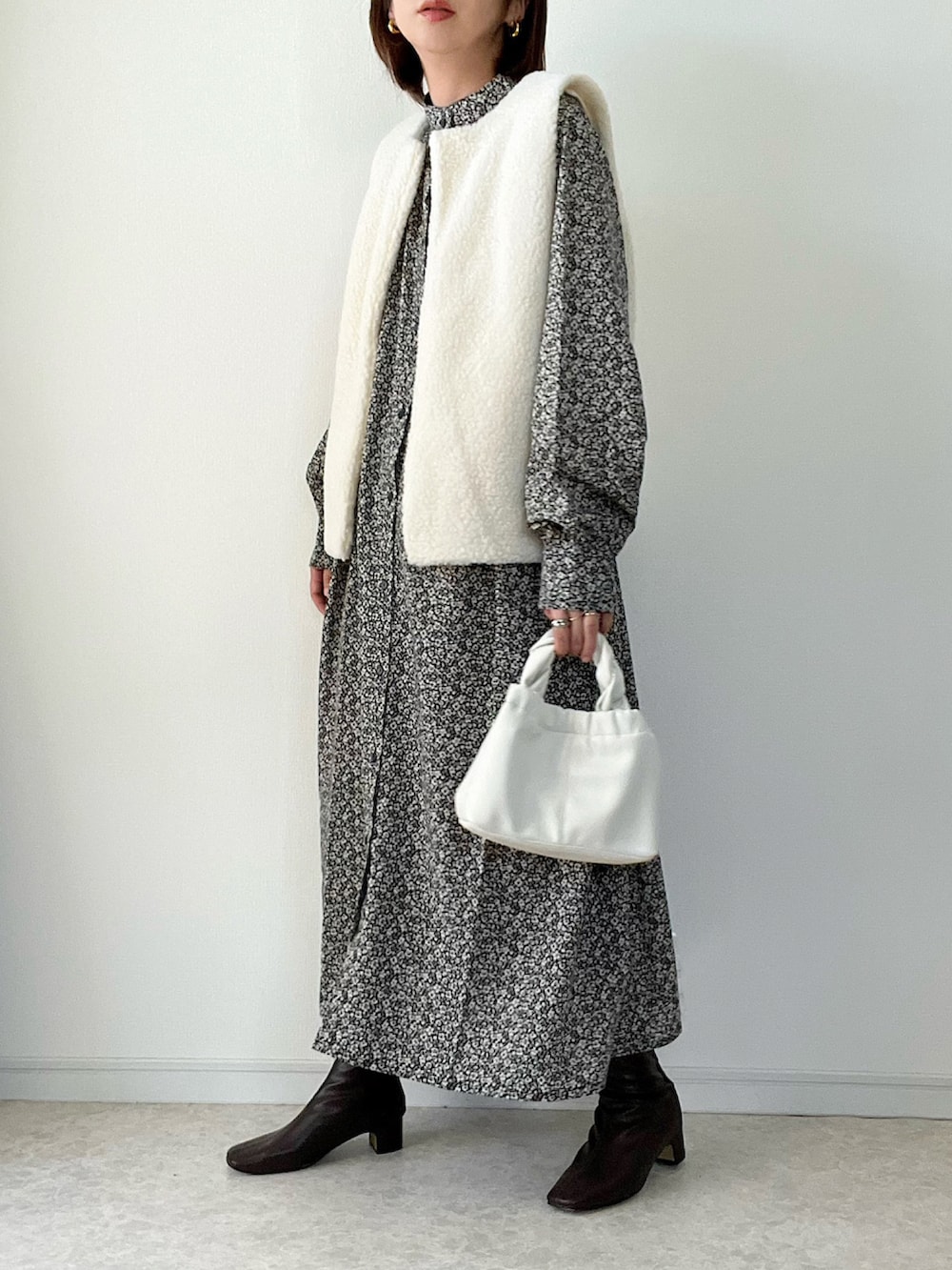 グリーン系のベスト、その他のワンピース、ブラック系のショルダーバッグを着用したレディースの夏コーディネートの2枚目の写真