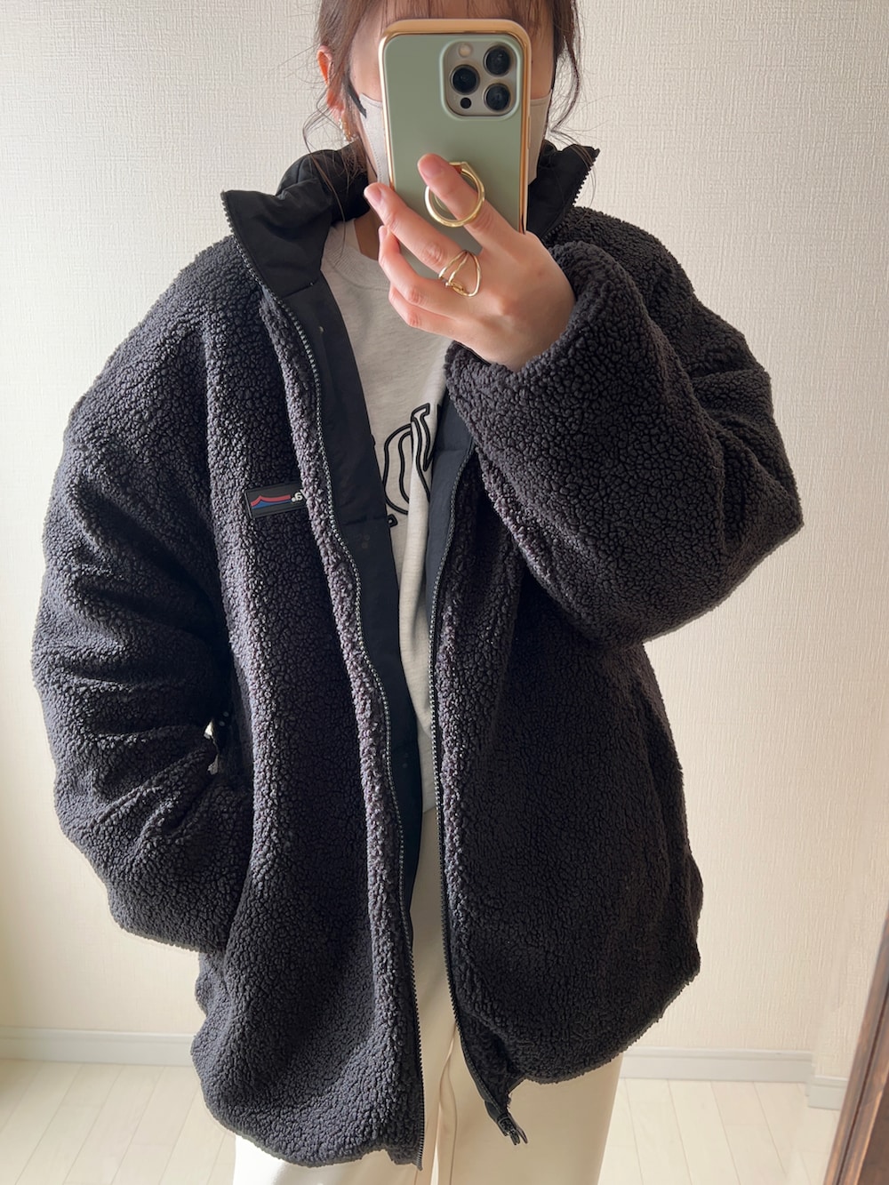 ブラック系のブルゾン、ホワイト系のスウェット、ホワイト系のパンツを着用したレディースの冬コーディネートの3枚目の写真