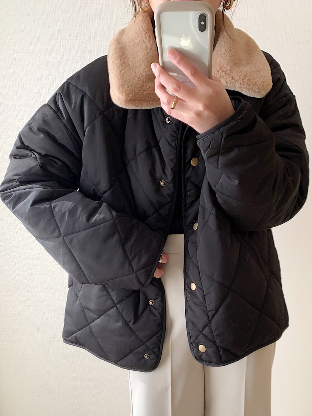 ブラック系のダウンジャケット/コート、ホワイト系のTシャツ/カットソー、ブラック系のショルダーバッグを着用したレディースの冬コーディネートの2枚目の写真