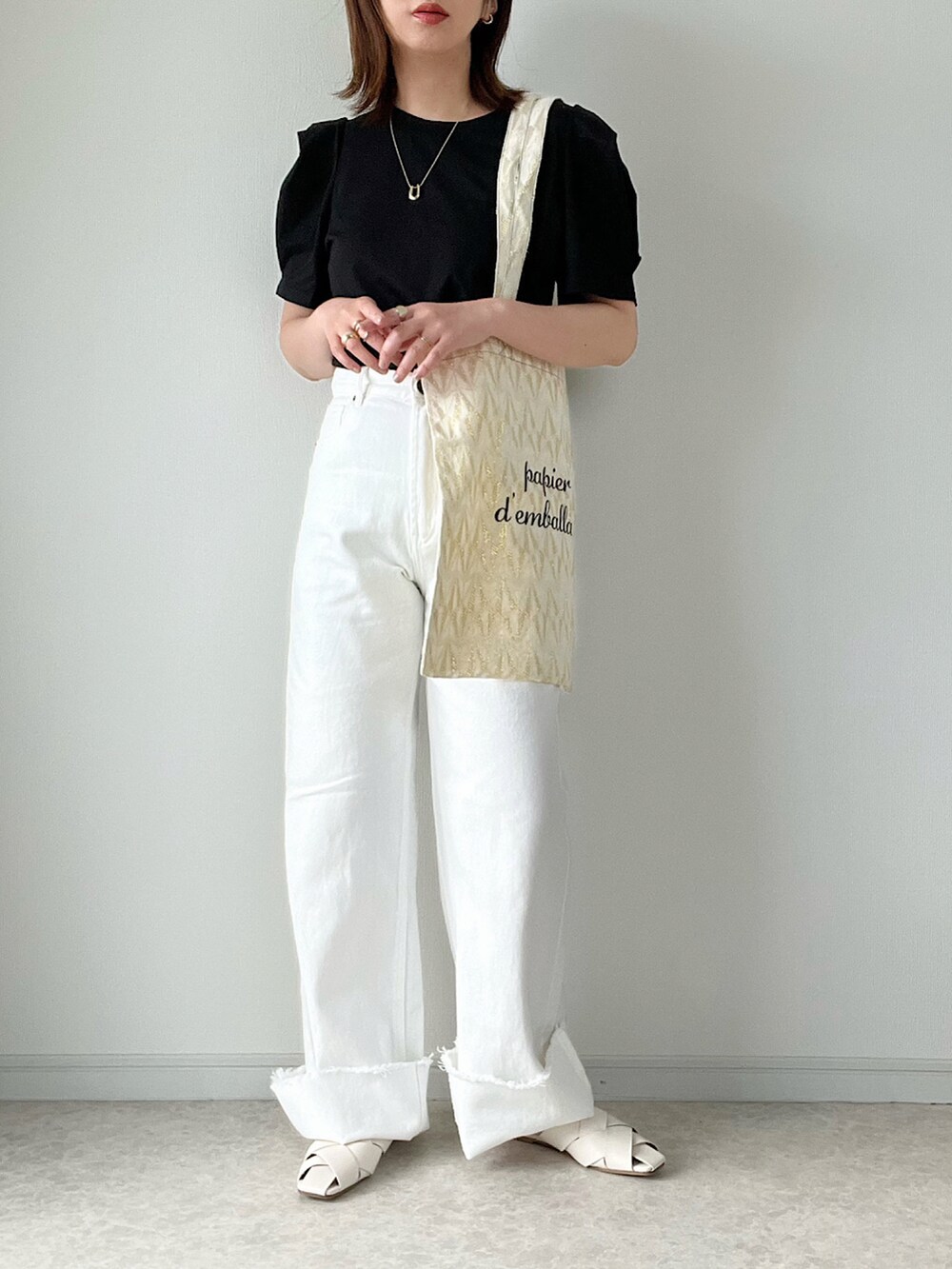 ブラック系のTシャツ/カットソー、ブルー系のデニムパンツ、ベージュ系のかごバッグを着用したレディースの春コーディネートの2枚目の写真