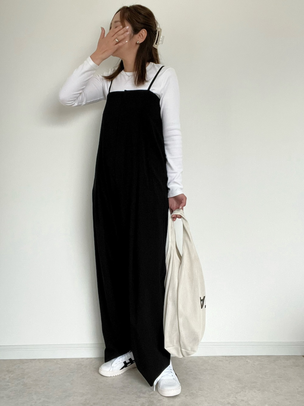 ブラック系のサロペット/オーバーオール、ブルー系のシャツ/ブラウス、ホワイト系のショルダーバッグを着用したレディースの春コーディネートの2枚目の写真