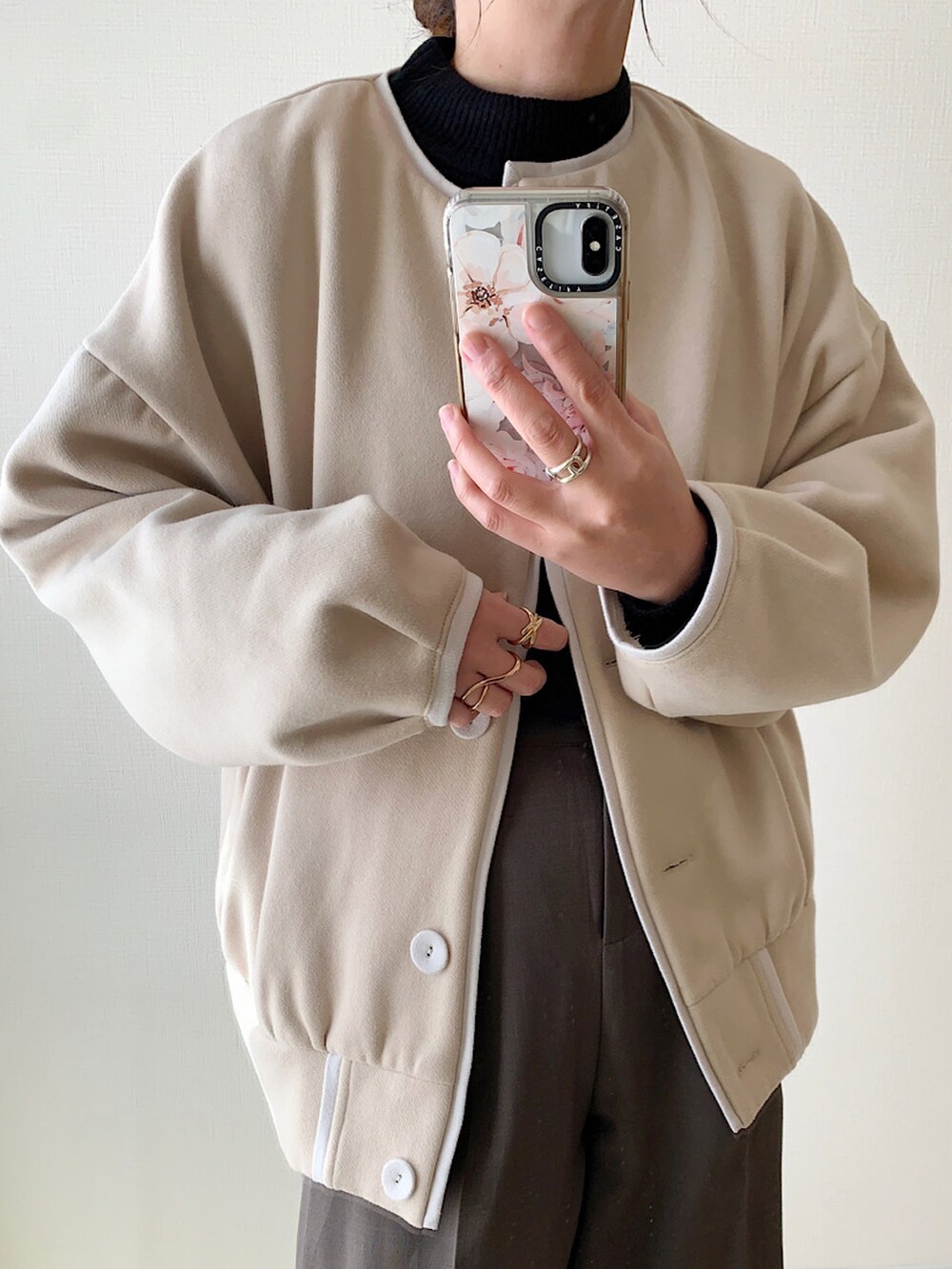 ベージュ系のカーディガン/ボレロ、ブラック系のニット/セーター、ブラウン系のスラックスを着用したレディースの秋コーディネートの2枚目の写真