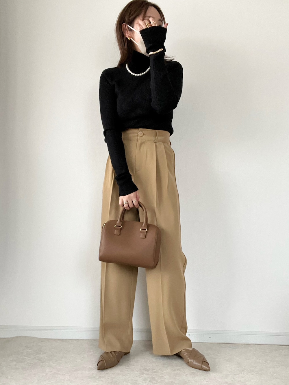 ブラック系のニット/セーター、ブルー系のデニムパンツ、ブラウン系のパンプスを着用したレディースの秋コーディネートの2枚目の写真