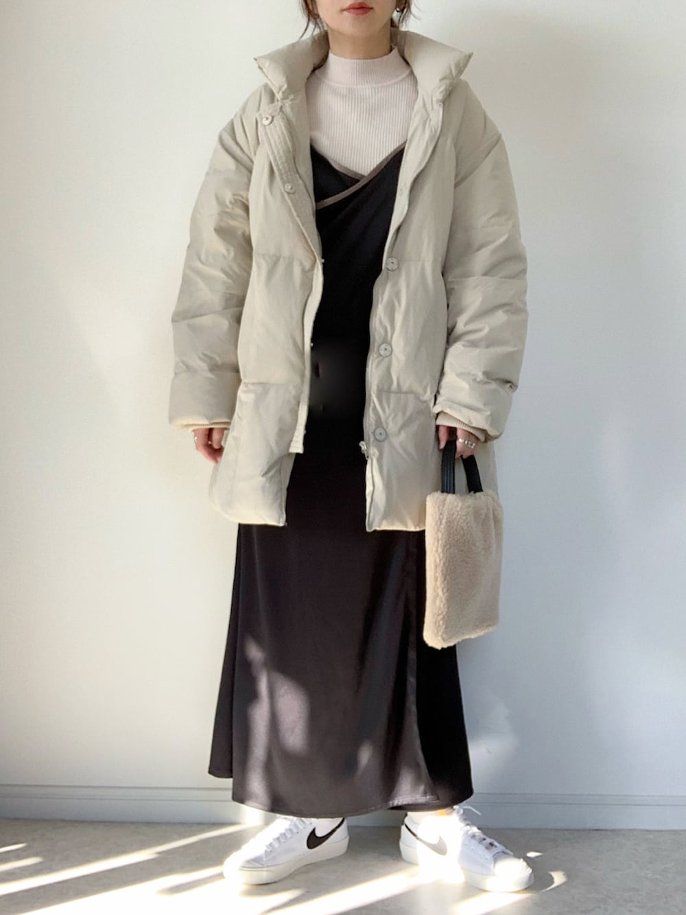 ベージュ系のダウンジャケット/コート、ホワイト系のTシャツ/カットソー、グレー系のスカートを着用したレディースの冬コーディネートの2枚目の写真