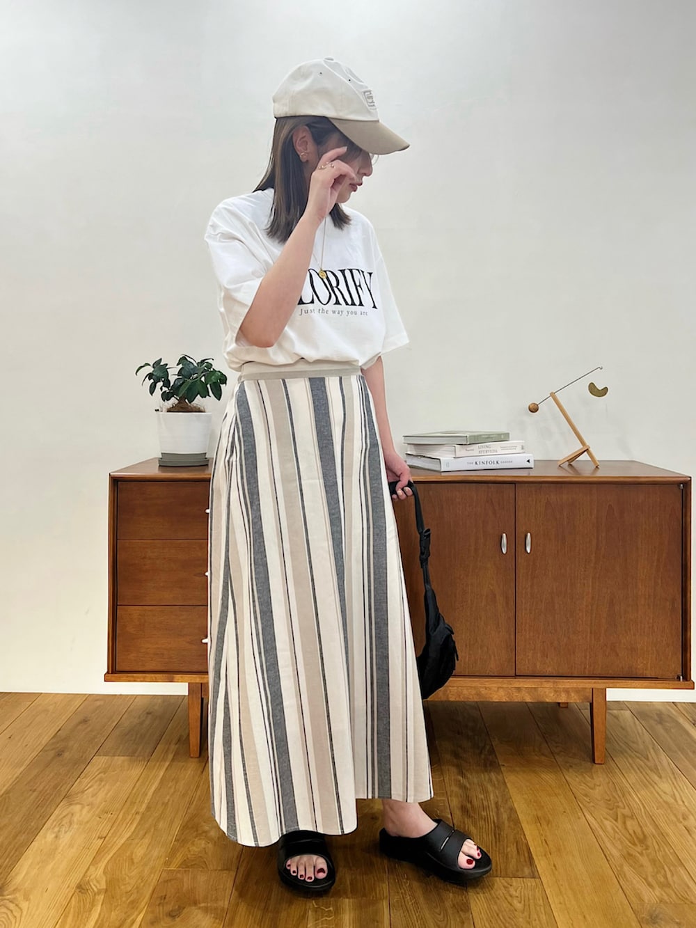 ホワイト系のニット/セーター、ブラック系のTシャツ/カットソー、ブルー系のデニムパンツを着用したレディースの春コーディネートの3枚目の写真