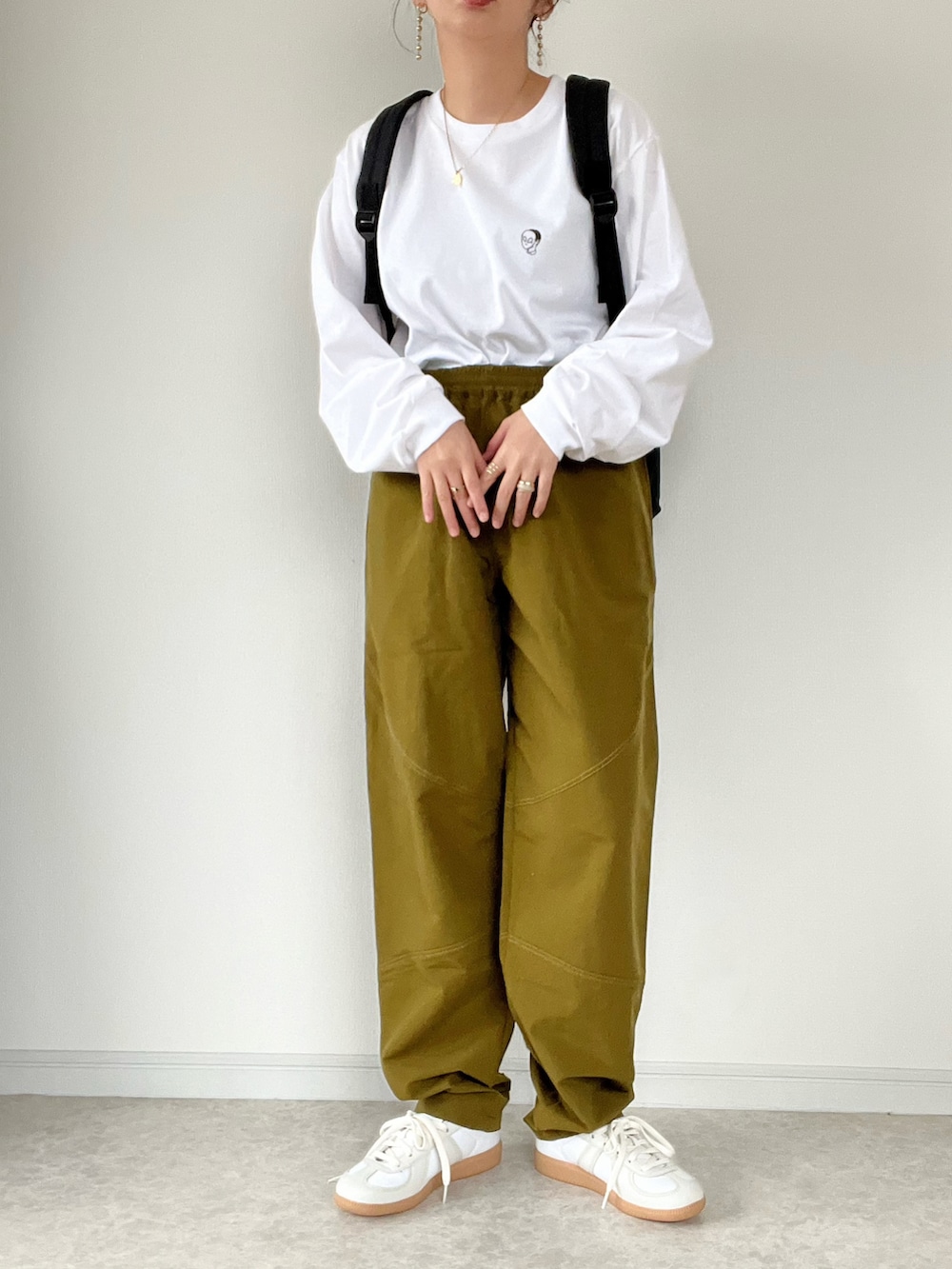 ブラック系のその他アウター、ブラック系のバックパック/リュック、ホワイト系のTシャツ/カットソーを着用したレディースの冬コーディネートの2枚目の写真