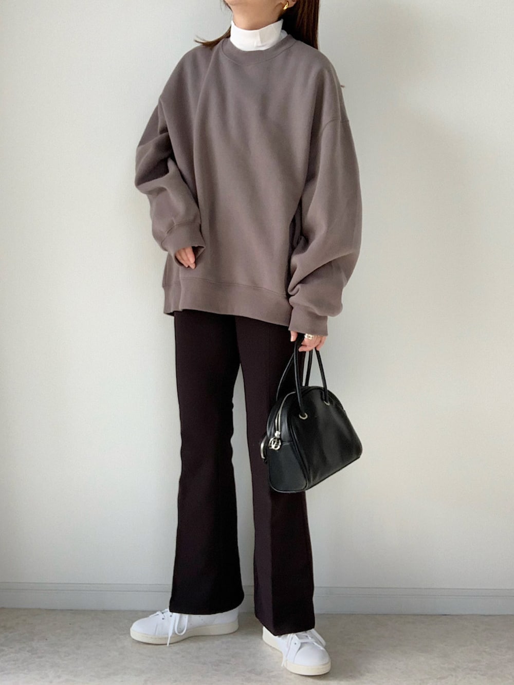 ホワイト系のニット/セーター、ホワイト系のTシャツ/カットソー、ブラック系のパンツを着用したレディースの冬コーディネートの2枚目の写真