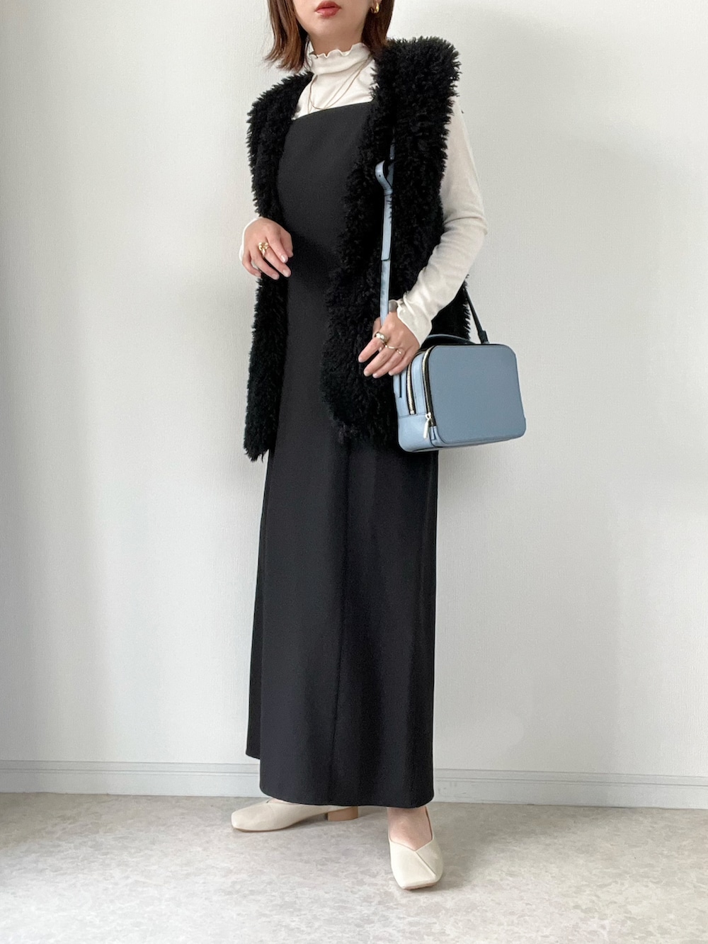 ブラック系のベスト、ホワイト系のスウェット、ブラウン系のその他パンツを着用したレディースの秋コーディネートの3枚目の写真